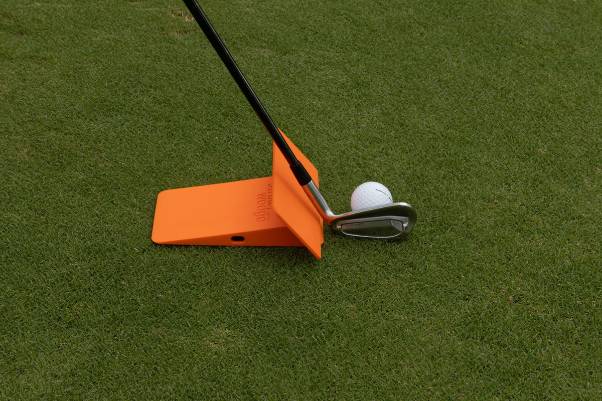 Strike Wedge with the wall attachment/ruler standing at its back, set on the inside of the ball beside the heel of the club
