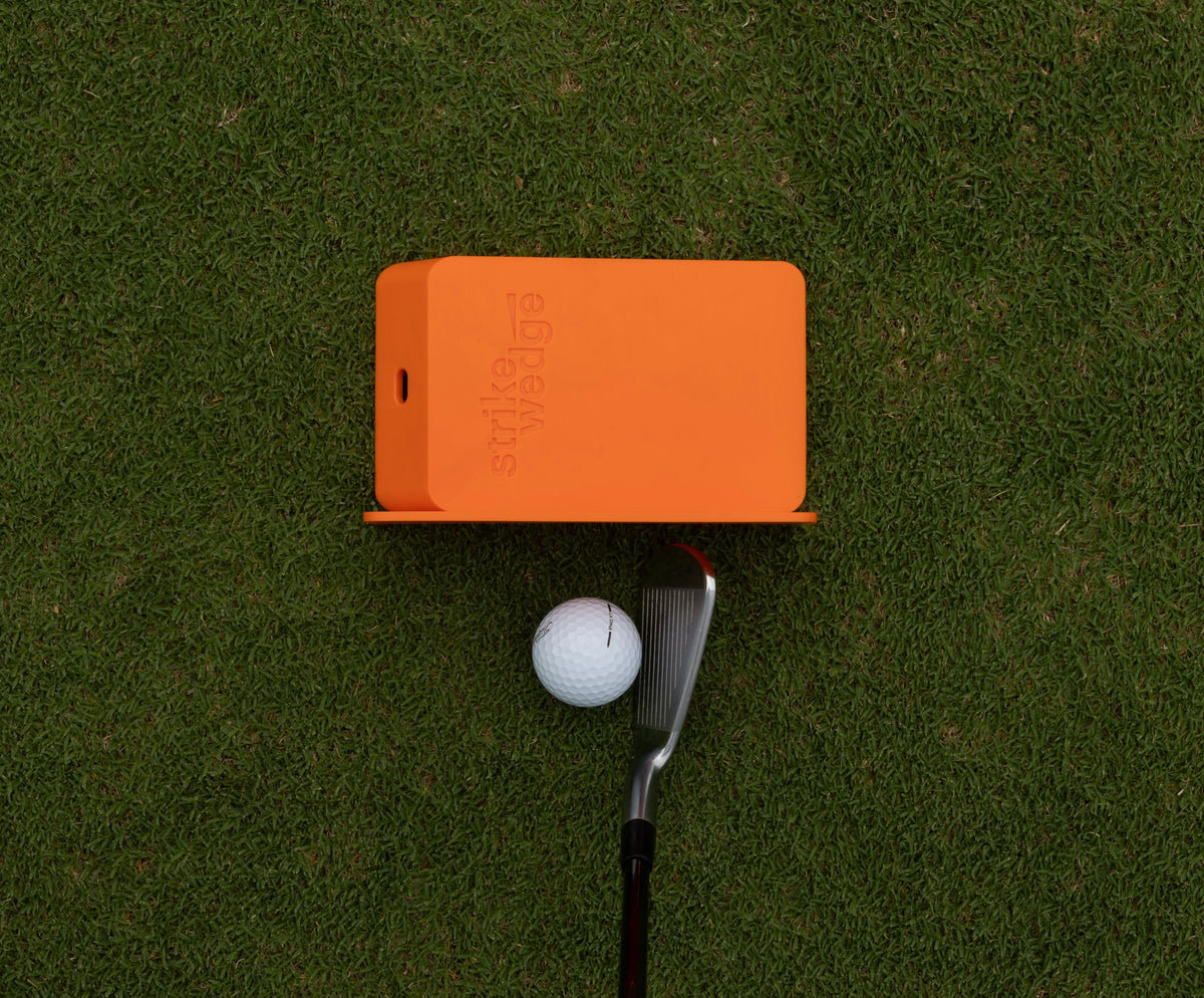 Top-down view of Strike Wedge with the wall attachment/ruler fixed to its side, set on the outside of the ball just beyond the toe of the club